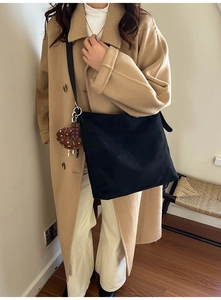 Detail of a large black shoulder bag with cute chocolate and donut charms on a coat