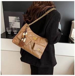 Détail du sac bandoulière vintage marron matelassé avec chaîne dorée et perles