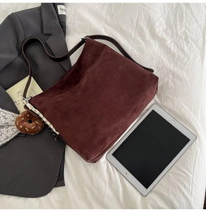 Detail view of large dark red suede tote bag with brown strap for office commute
