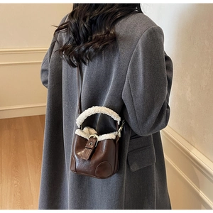 Détail du sac à bandoulière marron vintage avec garniture en peluche blanche et boucle