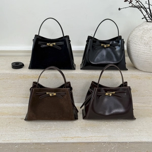 Detail of four retro matte and glossy bucket bags on stone steps with lock hardware