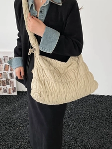 Chic beige quilted nylon cloud bag with pleated textures and adjustable crossbody strap