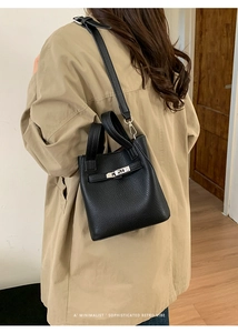 Detail of black lychee grain leather bucket bag with silver buckle and shoulder strap