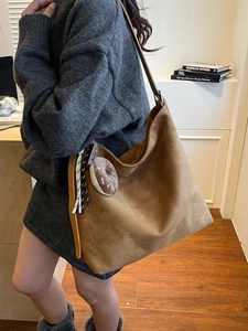 Minimalist brown suede tote bag with plush donut pendant on shoulder strap