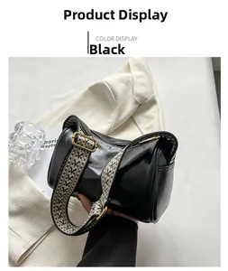 Détail du sac cylindrique en similicuir noir avec bandoulière large à motifs géométriques