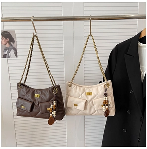 Détail de sacs à bandoulière matelassés avec chaîne en métal et breloque en perles