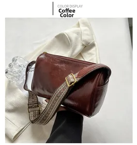Détail du sac Boston marron café avec une large bandoulière à motif géométrique