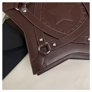 Detailaufnahme der braunen sternförmigen Ledertasche mit Silbernieten und Ringbeschlägen