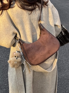 Retro-Schultertasche aus dunkelbraunem Wildleder in Halbmondform mit Plüsch-Anhänger