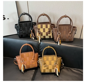 Detail of five woven leather handbags in various colors featuring bohemian bead charms