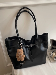 Classic black vintage leather tote bag with shoulder straps and brown bear keychain