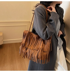 Dettaglio della borsa tote in pelle scamosciata marrone con frange lunghe e finitura opaca