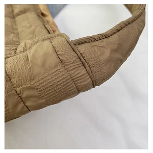 Detail showing the reinforced stitching on the khaki quilted tote bag shoulder strap
