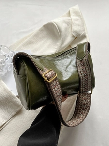 Sac cylindrique vert olive en cuir ciré avec une bandoulière tissée colorée