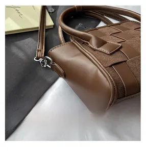 Close-up of dark brown woven handbag showing premium leather texture and stitching