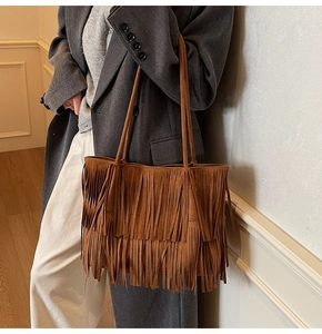 Close-up of bohemian brown suede tote bag with layered fringe and slim shoulder straps