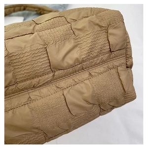 Detail of khaki quilted dumpling bag showing pleated bubble texture and puffy fabric