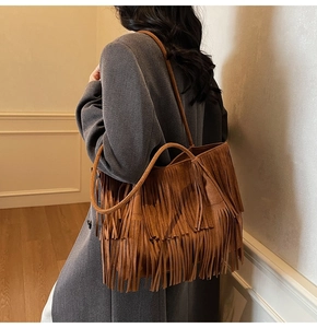 Dettaglio della borsa tote bohémien in camoscio marrone con lunghe frange