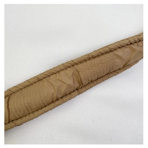 Macro shot of brown quilted pleated shoulder strap with soft padding texture