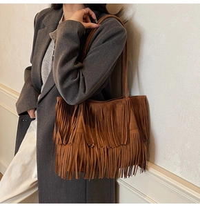 Primo piano della borsa tote in pelle scamosciata marrone con frange e spalline sottili