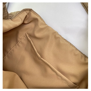 Close-up of the internal pocket and lining of the quilted tote bag in brown fabric