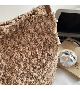 Vue détaillée d'un cabas en peluche texturé avec des anses en cuir marron contrasté