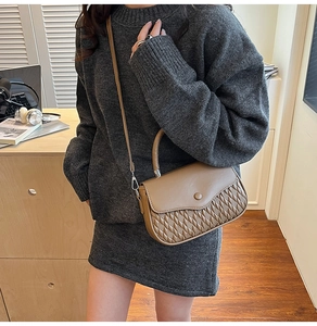 Brown leather crossbody bag with woven texture detail and adjustable shoulder strap
