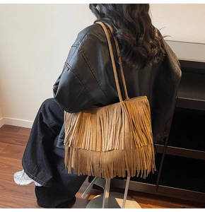Dettaglio borsa tote in pelle scamosciata marrone con lunghe frange e tracolla sottile