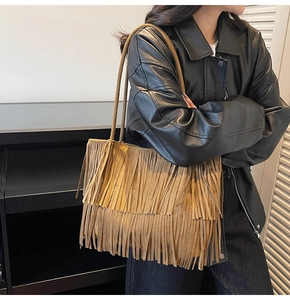 Dettaglio della borsa tote in pelle scamosciata marrone con frange doppie e spalline sottili