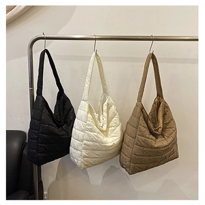 Detailed display of three quilted tote bags in black, white, and brown with grid texture
