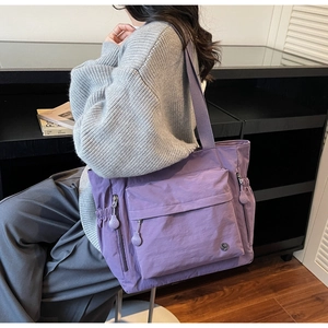 Detail of purple waterproof nylon tote bag with functional zipper side pockets