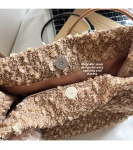 Détail du fermoir magnétique sur un sac seau en laine camel pour une ouverture facile