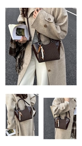 Detail der dunkelbraunen Eimer-Tasche mit Karomuster, Perlenquaste und glatter Textur