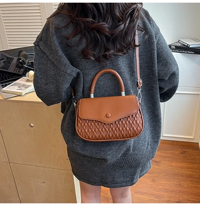 Brown quilted crossbody bag featuring elegant faux leather layers and a top handle