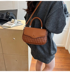 Caramel brown handbag with quilted pattern texture shown in a warm indoor lifestyle setting