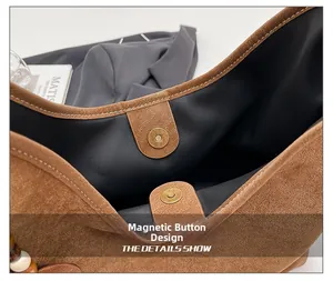 Detail of the magnetic snap closure on the brown suede shoulder bag with black lining