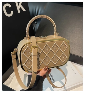 Macro detail of khaki leather box bag with embroidered B pattern and metal handle