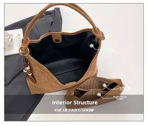 Detail view of suede tote interior compartments with wooden beads and zipper pouch