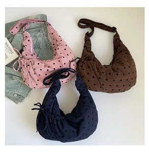 Détail de trois sacs cabas en velours côtelé à pois en rose, marron et bleu marine
