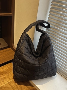 Chic black quilted puff hobo bag with cloud-like texture and soft nylon shoulder strap
