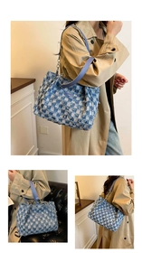 Detailed close-up of blue and white checkered denim tote bag with frayed edges and leather strap