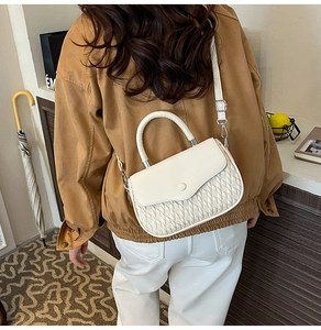 Chic cream semi-circle crossbody bag with woven texture shown on a female model