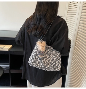 Detailansicht der schwarz-weißen Tweed-Tragetasche mit einem süßen Teddybär-Schlüsselanhänger
