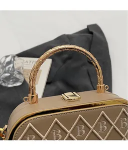 Detail of khaki leather handbag with B-letter embroidery and gold braided handle