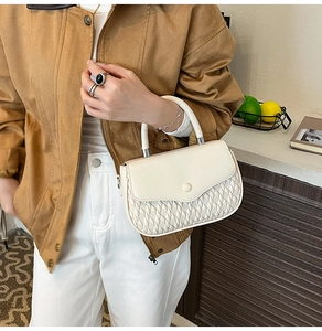 Detail of a chic cream-white PU leather handbag with elegant quilted diamond patterns