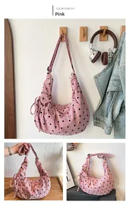Detailed view of pink polka dot drawstring hobo bag with corduroy texture for women