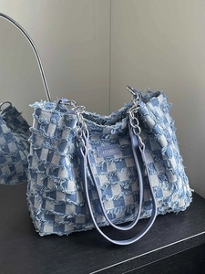 Blue and white checkerboard tote bag in denim with fringe edges and metal chain strap