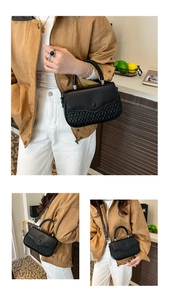 Close-up of the woven texture and flap design on a black leather crossbody handbag