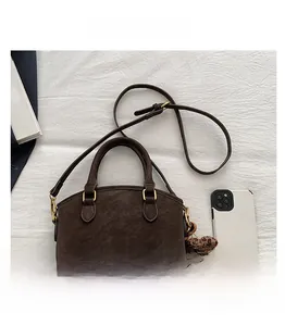 Flat lay of vintage dark brown faux leather handbag with cute teddy bear charm