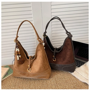 Detail of hobo shoulder bags in brown suede with vintage wooden bead charms and leather trim